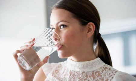 Девушка пьет воду из стакана